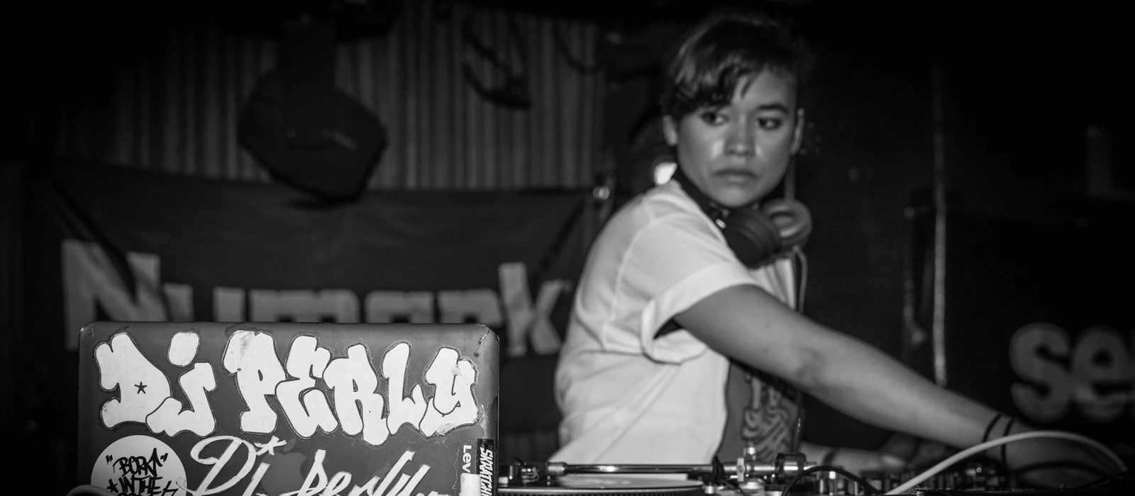 DJ Perly behind the turntables at a live set